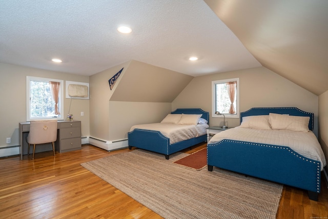 bedroom with lofted ceiling, a baseboard radiator, multiple windows, and hardwood / wood-style floors