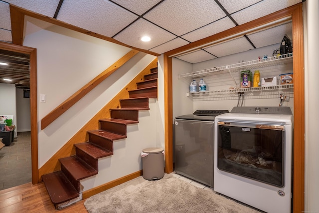 washroom with light hardwood / wood-style flooring and washing machine and dryer