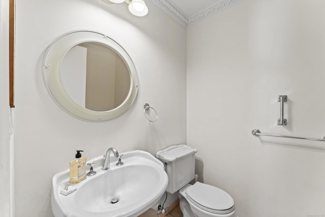 bathroom with crown molding, toilet, and sink