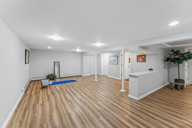 workout room featuring a baseboard heating unit and light hardwood / wood-style floors