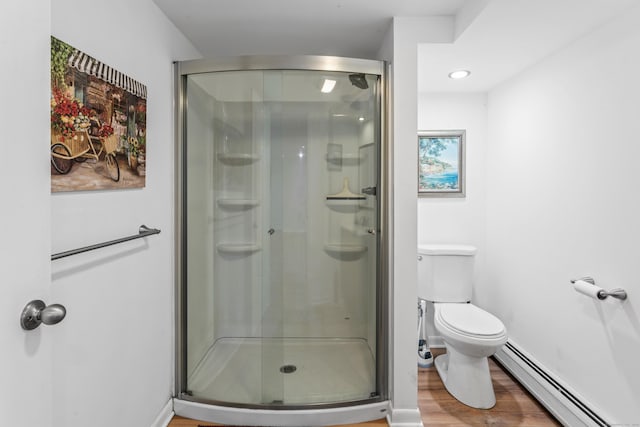 bathroom with a shower with door, a baseboard heating unit, hardwood / wood-style floors, and toilet