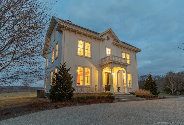 view of front of house featuring a balcony and central AC unit