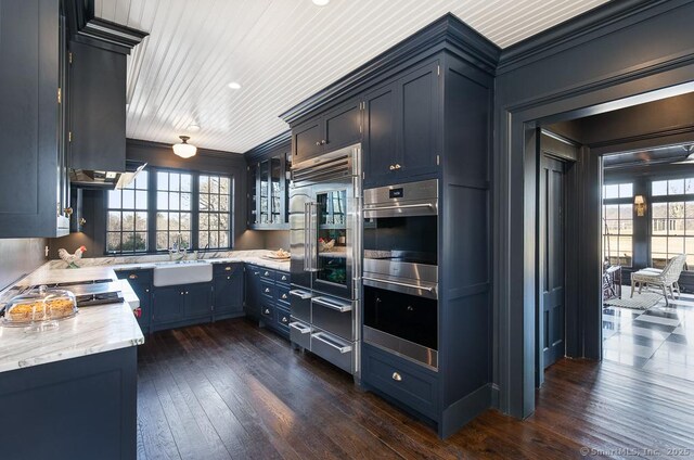 114 Walkley Hill Rd, Haddam, CT 06438 - kitchen featuring appliances with stainless steel finishes, dark wood-type flooring, ornamental molding, light stone counters, and blue cabinetry