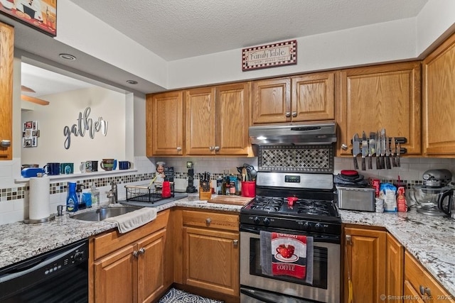 kitchen featuring black dishwasher, gas range, light stone countertops, a textured ceiling, and sink