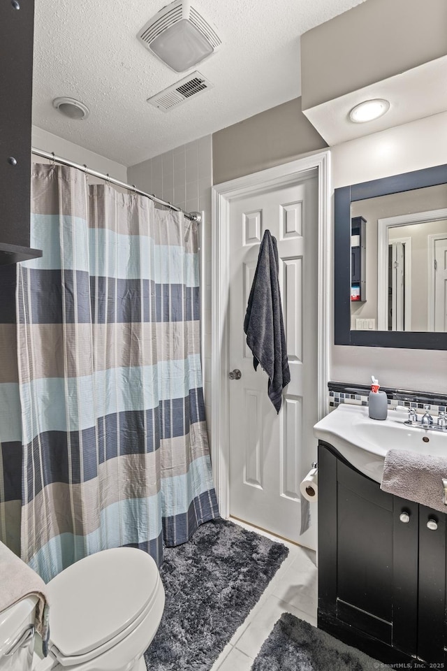 bathroom with a textured ceiling, toilet, a shower with shower curtain, and vanity