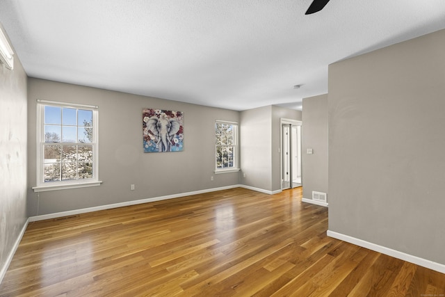 spare room with hardwood / wood-style flooring, plenty of natural light, and ceiling fan