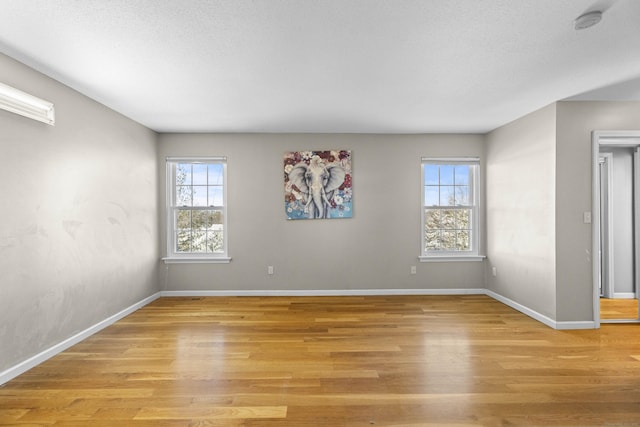 spare room featuring light hardwood / wood-style flooring and a textured ceiling