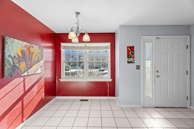 tiled entrance foyer featuring a chandelier