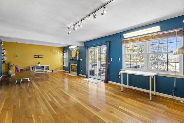 interior space featuring hardwood / wood-style floors, track lighting, and a textured ceiling