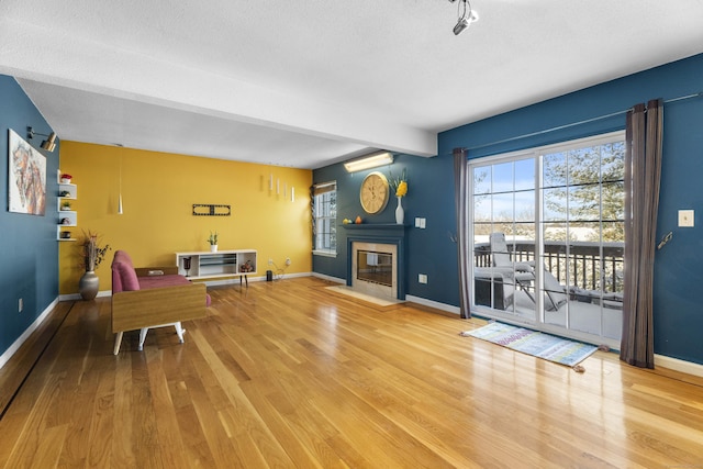 interior space featuring hardwood / wood-style flooring, a textured ceiling, and beamed ceiling