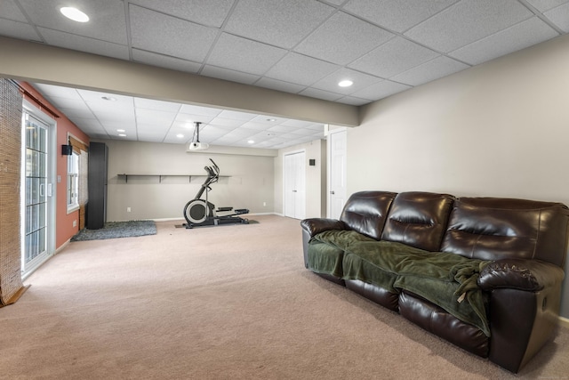 living room featuring carpet floors and a drop ceiling