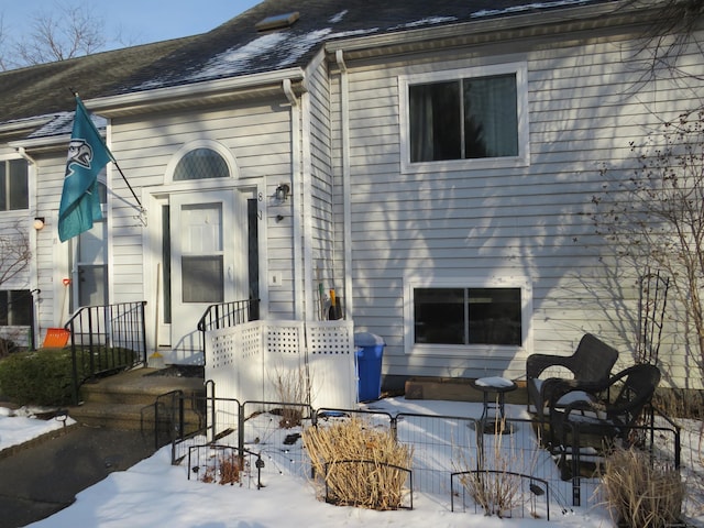 view of snow covered rear of property