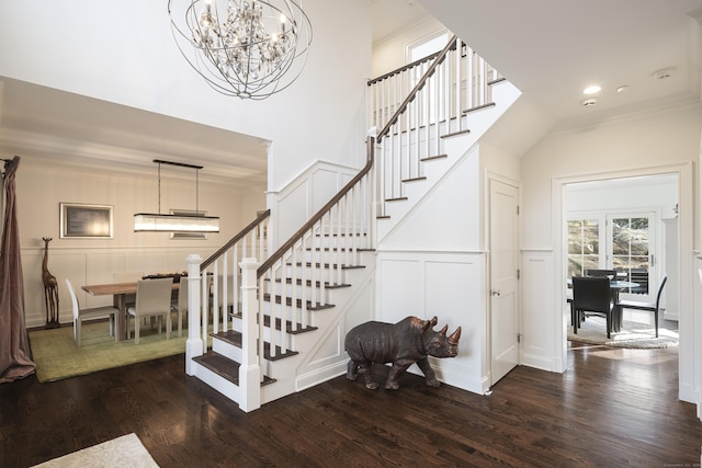 staircase featuring ornamental molding, wood-type flooring, and a chandelier