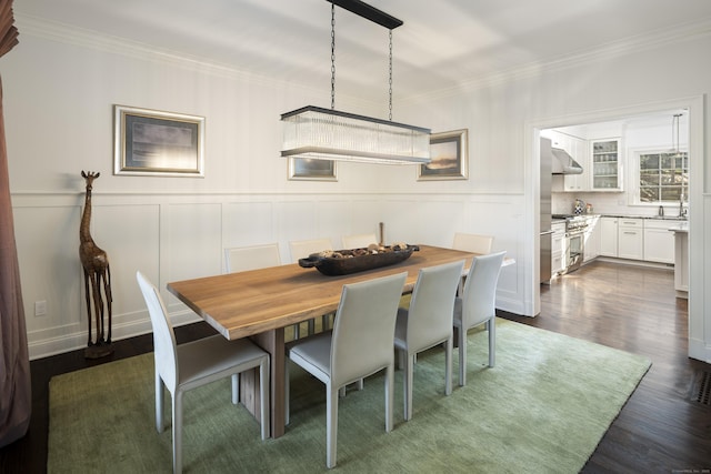 dining space with crown molding, dark hardwood / wood-style floors, and sink