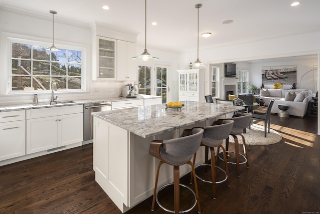 kitchen with dishwasher, sink, white cabinets, a center island, and dark wood-type flooring