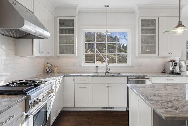 kitchen with white cabinetry, high end stainless steel range, light stone counters, and decorative backsplash