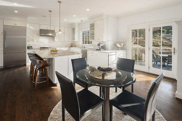 dining room featuring sink, crown molding, and dark hardwood / wood-style floors