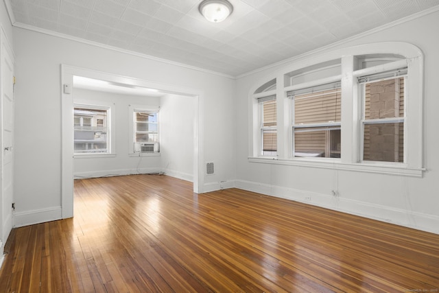 empty room with hardwood / wood-style flooring, crown molding, and cooling unit