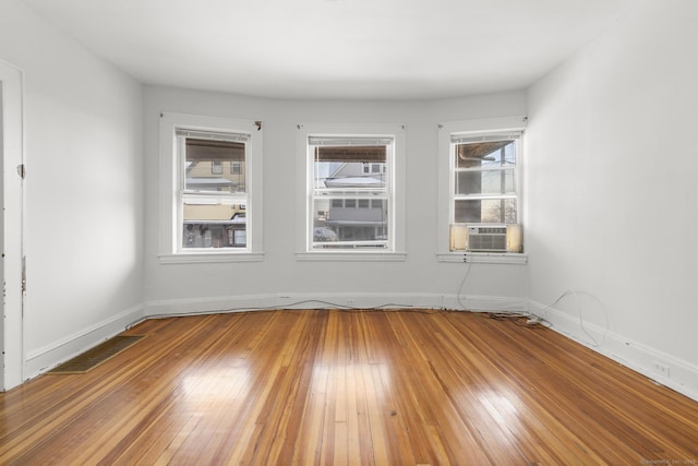 spare room featuring hardwood / wood-style floors and cooling unit