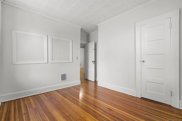 unfurnished room featuring ornamental molding and dark hardwood / wood-style flooring