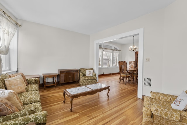 living room featuring a notable chandelier and wood-type flooring