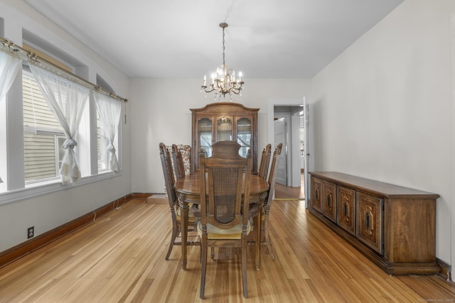 dining room with an inviting chandelier and light hardwood / wood-style flooring