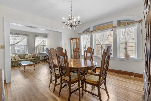 dining room featuring a notable chandelier and light hardwood / wood-style flooring