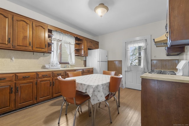 kitchen with stove, light hardwood / wood-style flooring, and white fridge