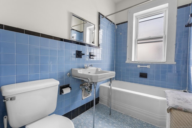 full bathroom featuring sink, tile walls, tile patterned floors, toilet, and tiled shower / bath