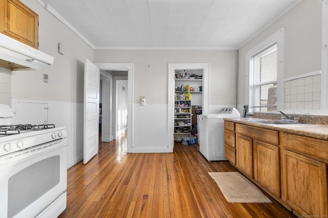 kitchen with dark hardwood / wood-style floors, washer / clothes dryer, sink, ornamental molding, and white gas stove