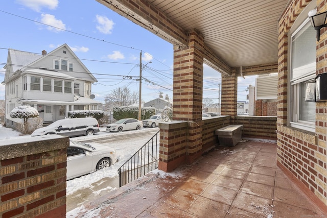 snow covered patio featuring covered porch