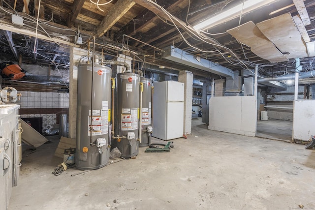 basement featuring water heater and white refrigerator