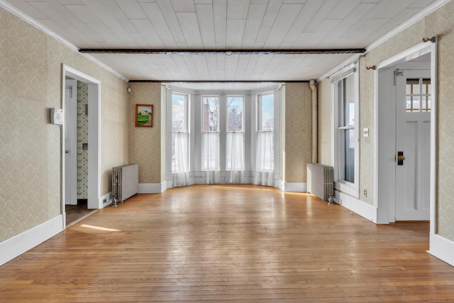 interior space with radiator, ornamental molding, and light hardwood / wood-style floors