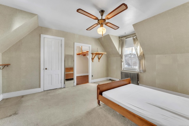 bedroom with vaulted ceiling, radiator, light carpet, and ceiling fan