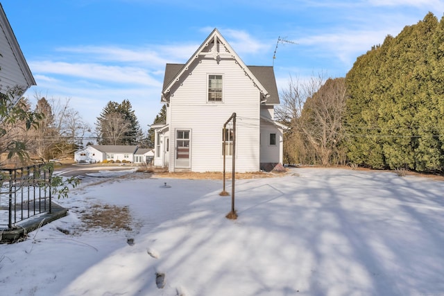 view of snow covered back of property