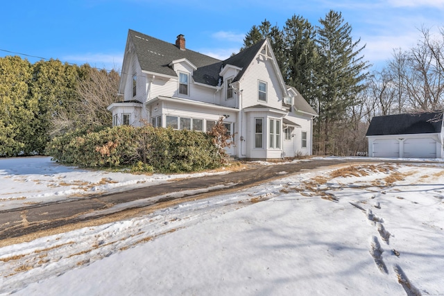 view of snow covered exterior with a garage and an outdoor structure