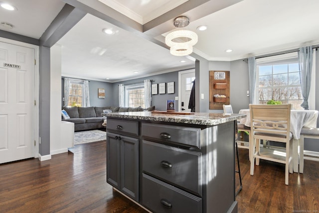 kitchen featuring crown molding, a center island, dark hardwood / wood-style floors, and beam ceiling