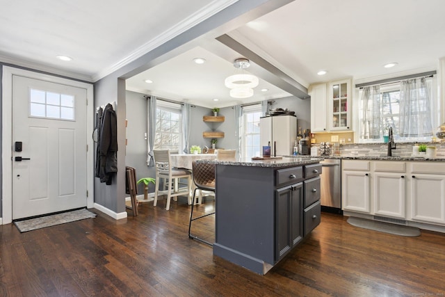 kitchen featuring refrigerator, dark stone countertops, white cabinets, a kitchen bar, and dark hardwood / wood-style flooring