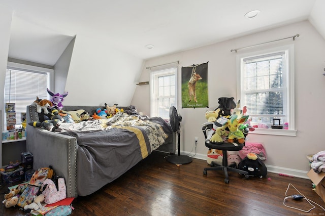 bedroom with dark wood-type flooring, vaulted ceiling, and multiple windows