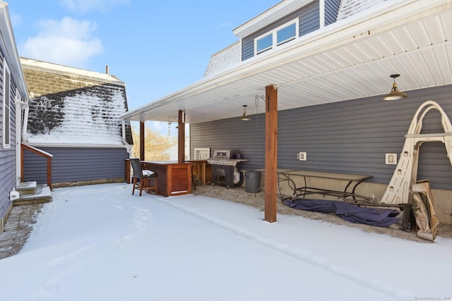 snow covered patio featuring a bar, grilling area, and ceiling fan