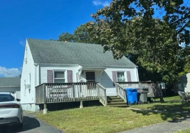 view of front of property with a front yard and a deck