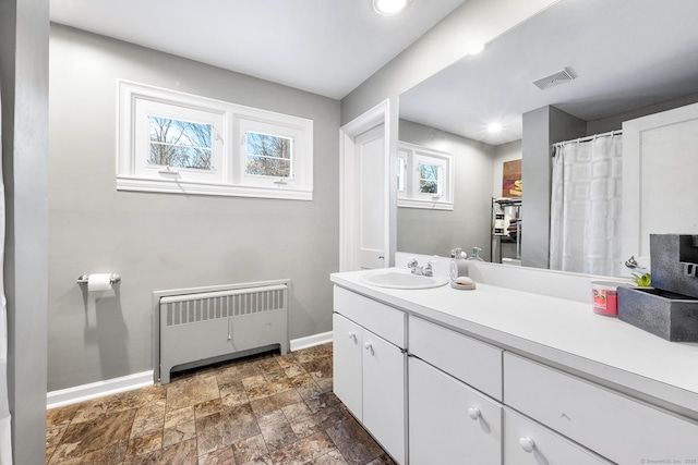 bathroom with a wealth of natural light, radiator, and vanity