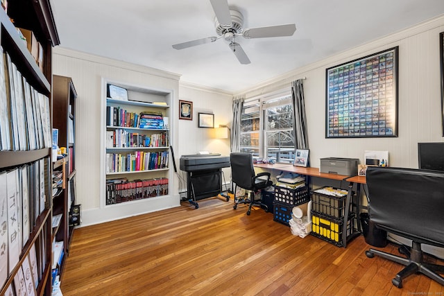 home office featuring ceiling fan, built in shelves, wood-type flooring, and ornamental molding