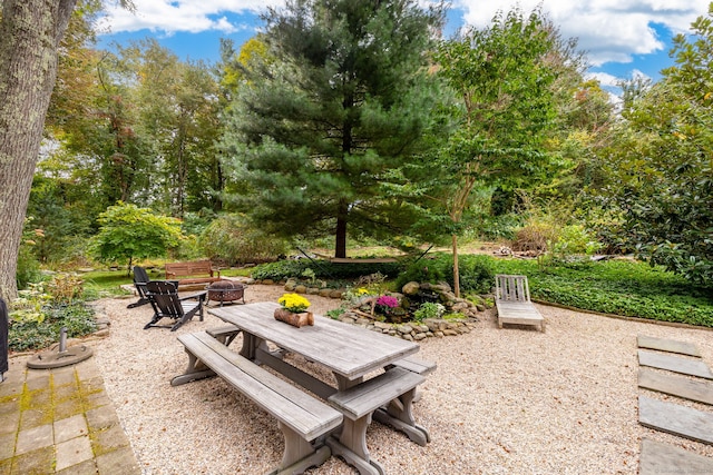 surrounding community featuring an outdoor fire pit and a patio area