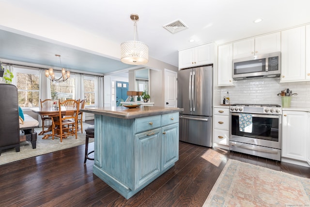 kitchen with stainless steel appliances, dark wood-type flooring, visible vents, and white cabinets