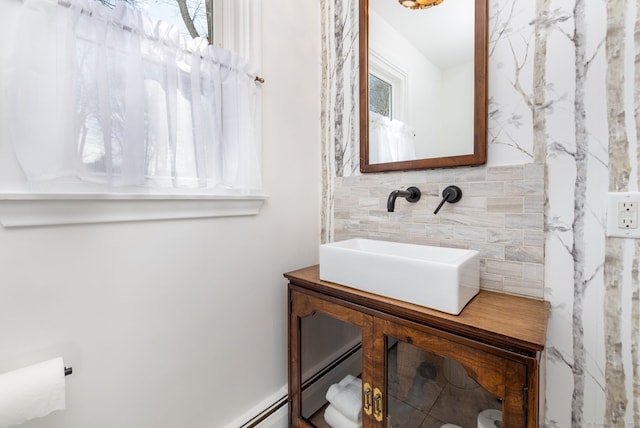 bathroom with decorative backsplash and a sink