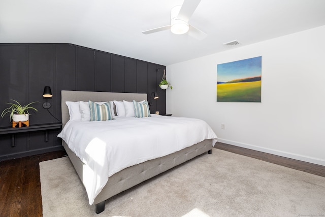 bedroom with lofted ceiling, visible vents, a ceiling fan, wood finished floors, and baseboards