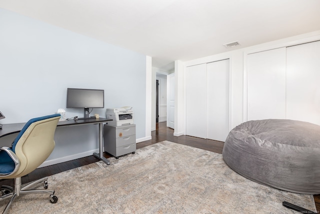 home office with baseboards, visible vents, and wood finished floors