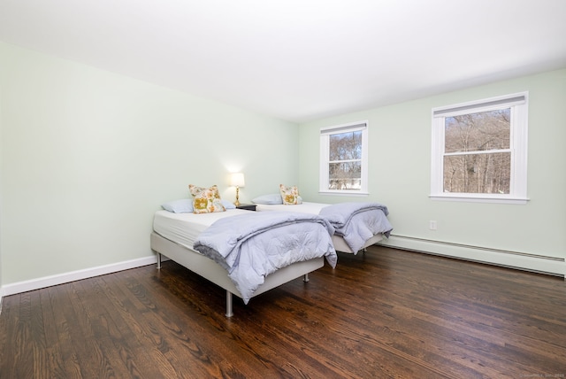 bedroom featuring baseboards, baseboard heating, and wood finished floors