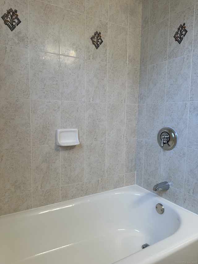 bathroom featuring tiled shower / bath